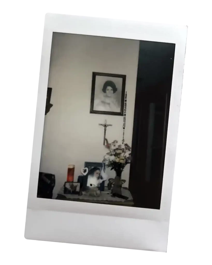 Image of a home with a black and white photo of a woman hanging above a crucifix