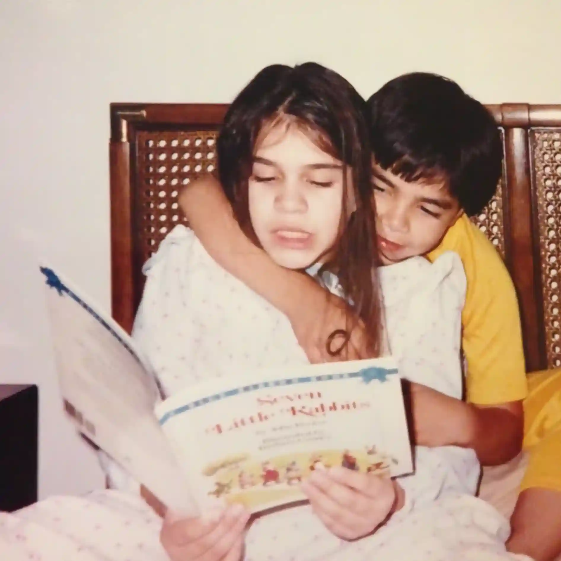 an old photo of Iliana Rocha reading with her brother as children